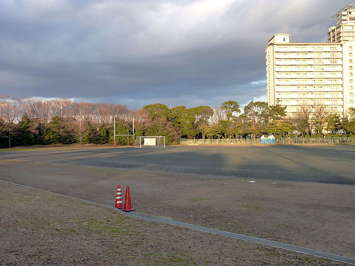 サッカーのグラウンドとゴールネットとマンションの景色の拡大写真