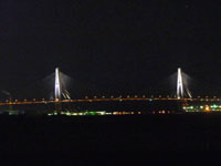 ライトアップされた海に架かる橋と夜景